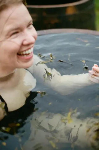 A happy lady enjoying a seaweed soak detox